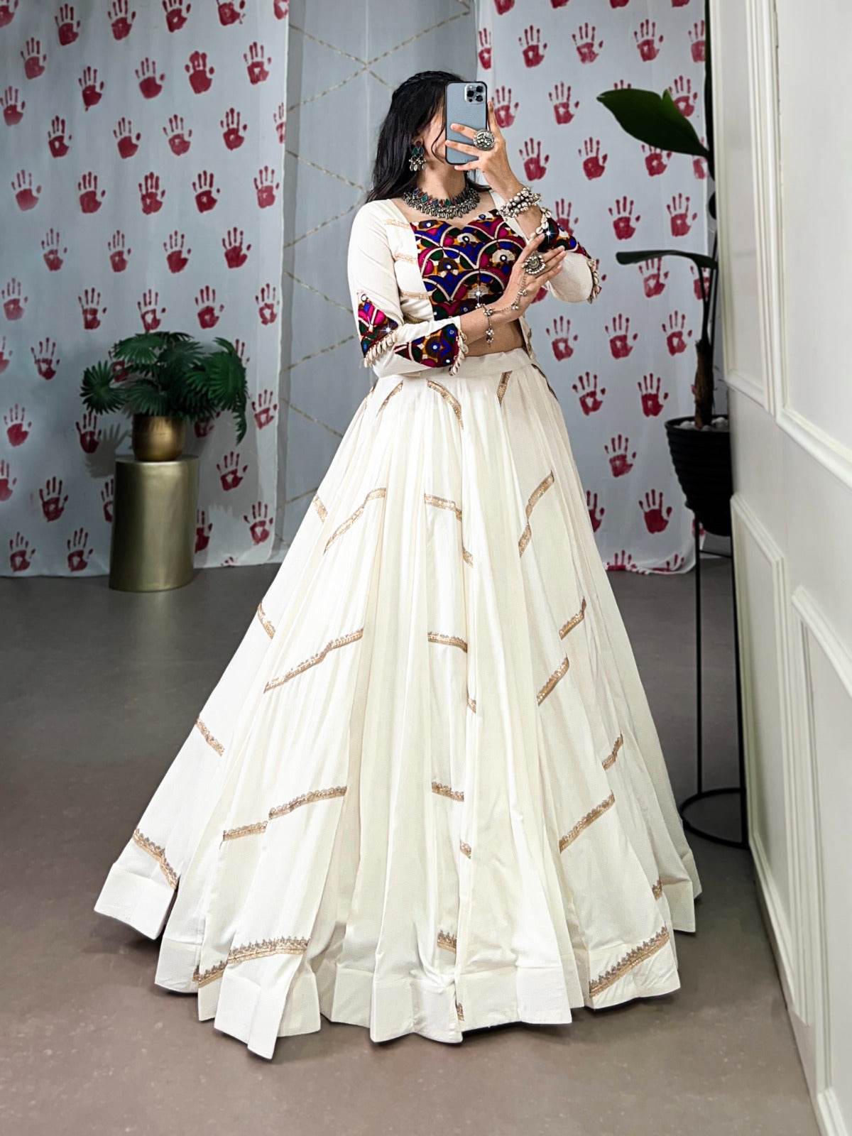 a woman in a flowing white cstands against a wall, emphasizing her elegant style and the dress's design - rpd fashion