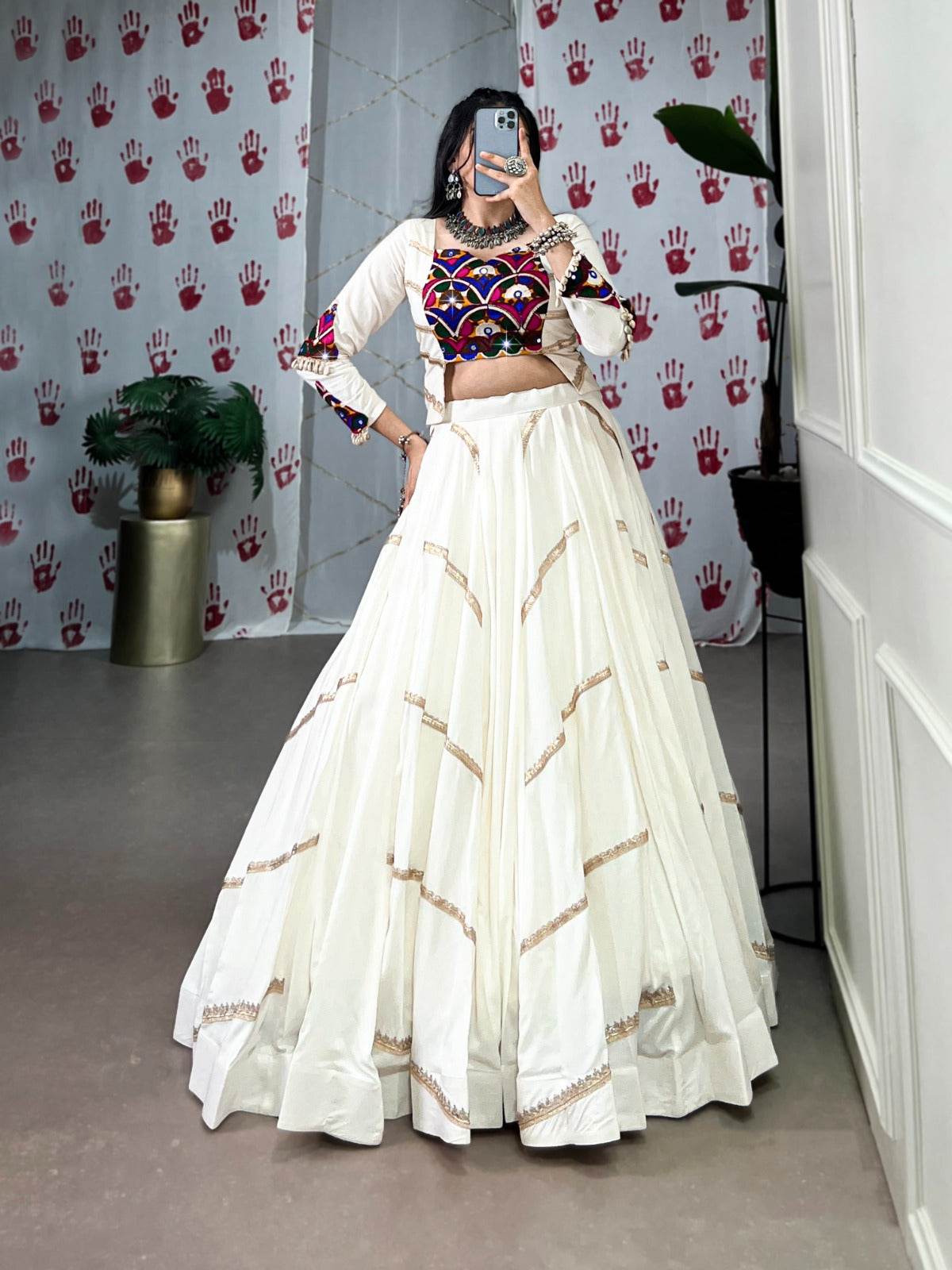 a woman in a flowing white cstands against a wall, emphasizing her elegant style and the dress's design - rpd fashion