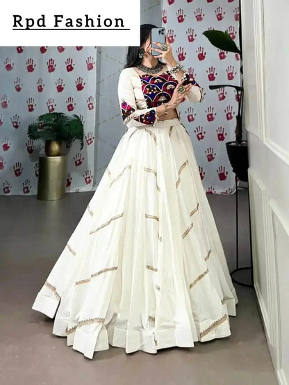 A woman in a flowing white cstands against a wall, emphasizing her elegant style and the dress's design - RPD Fashion