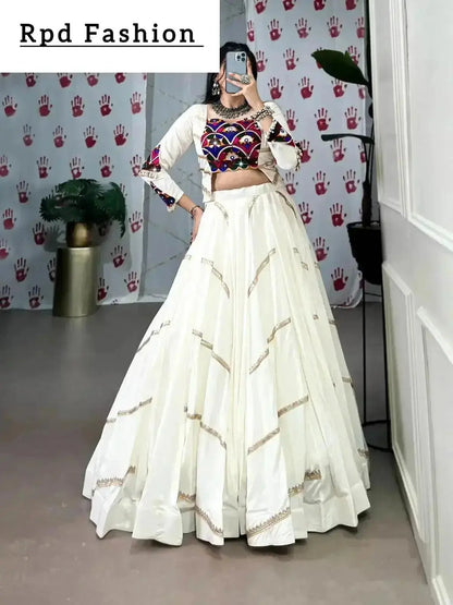 A woman in a flowing white cstands against a wall, emphasizing her elegant style and the dress's design - RPD Fashion