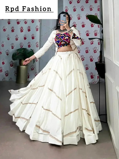 A woman in a flowing white cstands against a wall, emphasizing her elegant style and the dress's design - RPD Fashion