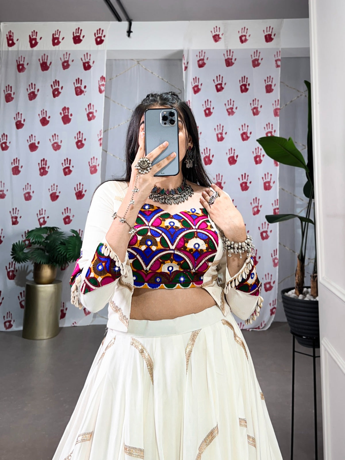 a woman in a flowing white cstands against a wall, emphasizing her elegant style and the dress's design rpd fashion
